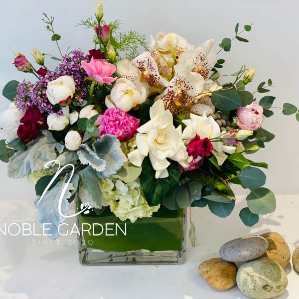 Mixed bouquet in a square glass vase with white and pink flowers
