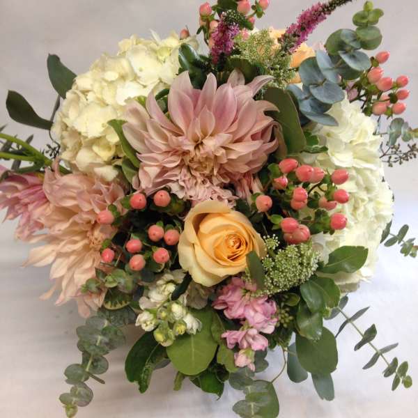 Bouquet of blush and cream flowers with pink berries and eucalyptus