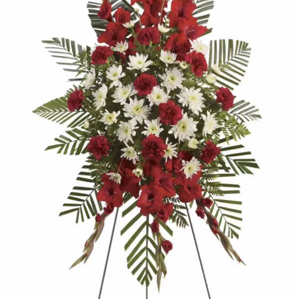 Standing floral spray with red gladiolus and white daisies on a metal easel