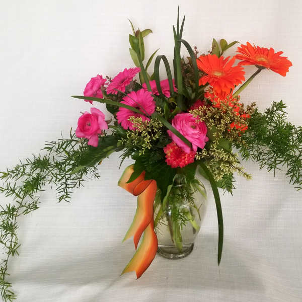 Pink and orange mixed bouquet in a clear glass vase