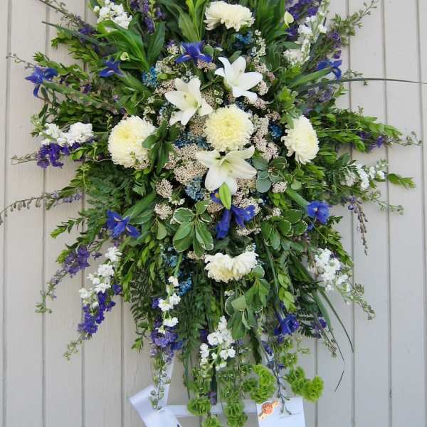Large standing floral spray with white lilies, chrysanthemums, and blue flowers