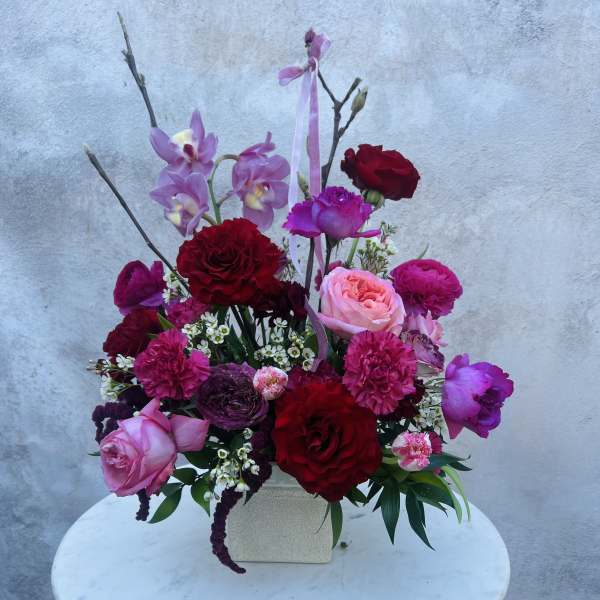 Pink and red floral arrangement in a square vase