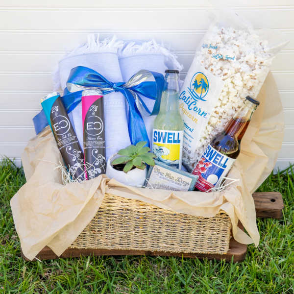 Gift basket with popcorn, soda bottles, chocolates, soap, and a small succulent