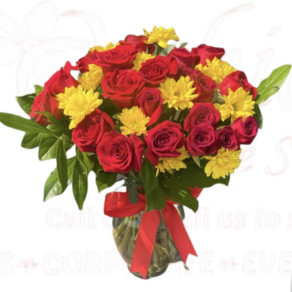 Bouquet of red roses and yellow daisies in a glass vase with a red ribbon