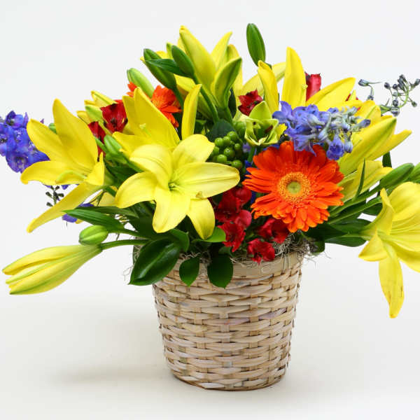 Yellow lilies and mixed flowers in a woven basket
