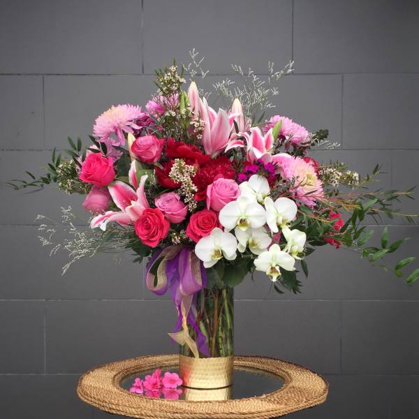 Pink and white mixed bouquet in a glass vase with ribbon
