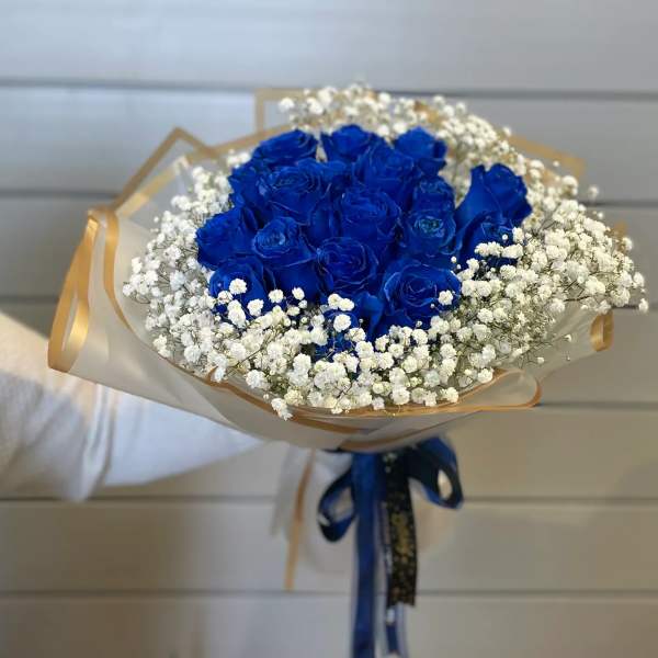 Bouquet of vivid blue roses with white baby's breath and gold-edged wrap