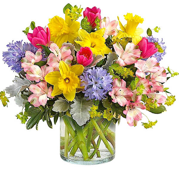 Mixed bouquet of yellow daffodils, pink tulips, and lavender flowers in a glass vase