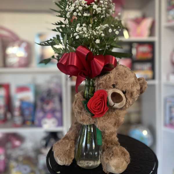 Red rose arrangement in a glass vase with a teddy bear