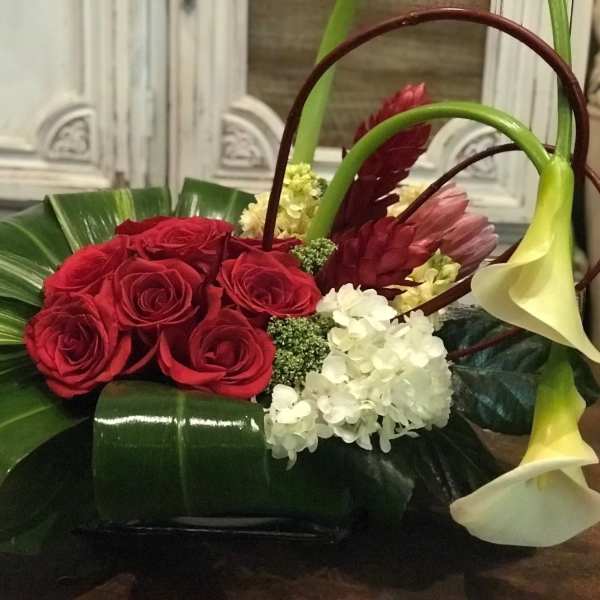 Red roses with white calla lilies and hydrangea in a low arrangement