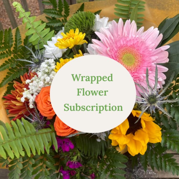 Wrapped bouquet with pink gerbera, orange roses, and yellow flowers