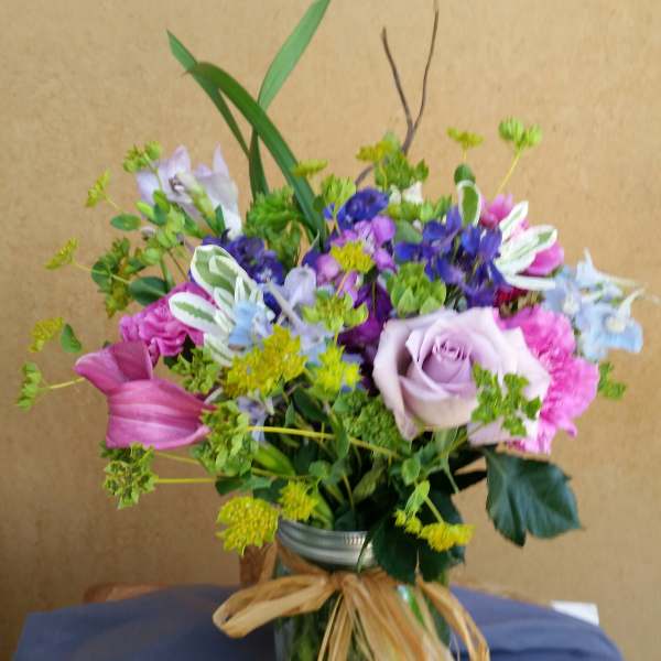 Mixed bouquet in a glass vase with pink, purple, and blue flowers