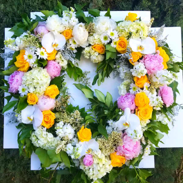 Heart-shaped floral wreath with white, pink, and yellow blooms