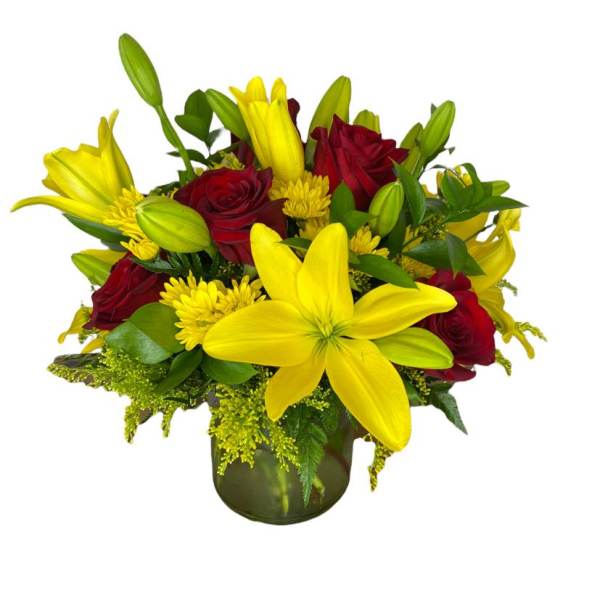 Yellow lilies and red roses arranged in a glass vase
