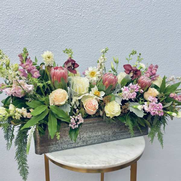 Mixed floral arrangement in a rectangular metal planter