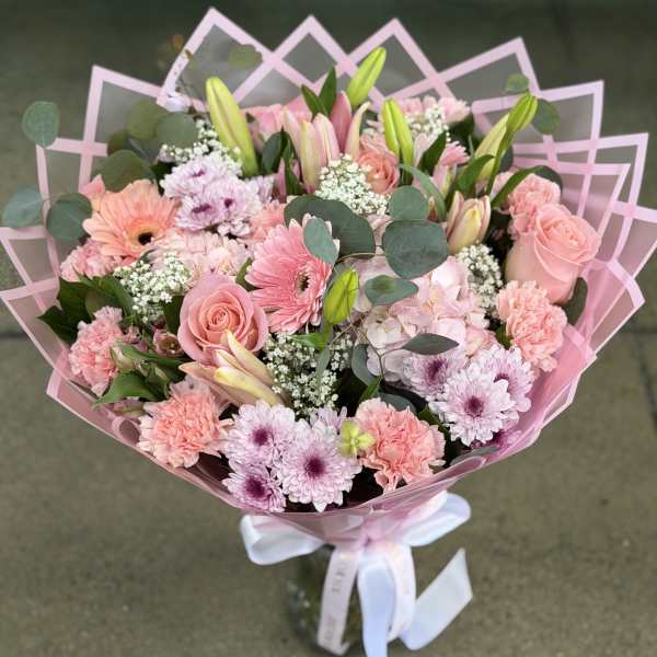Pink bouquet with roses, lilies, and daisies wrapped in pink paper