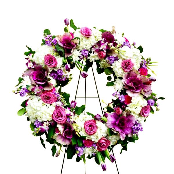 Circular floral wreath on an easel with pink, white, and purple flowers