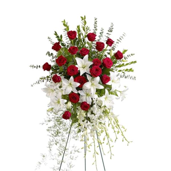 Standing floral spray with red roses and white lilies on an easel