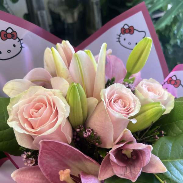 Pink roses and lilies in a bouquet with Hello Kitty wrapping