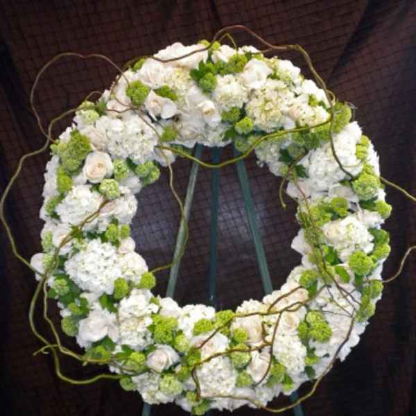 White and green floral wreath on a stand