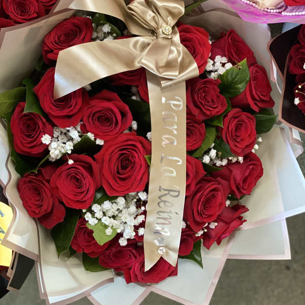 Bouquet of red roses wrapped with a gold ribbon