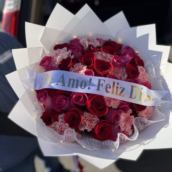 Bouquet of red roses and pink carnations with a "Te Amo! Feliz Día" ribbon