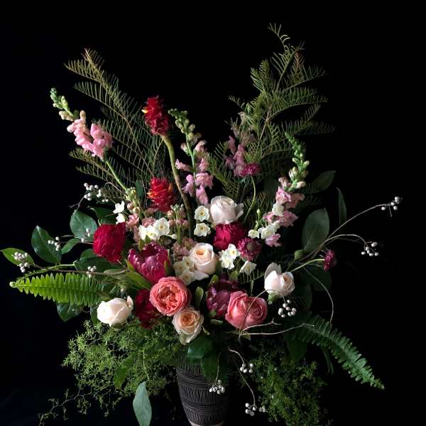 Tall mixed bouquet in a dark vase with pink and white blooms