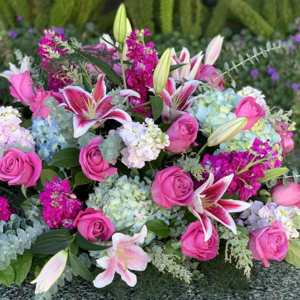 Pink roses, lilies, and hydrangeas in a low floral arrangement