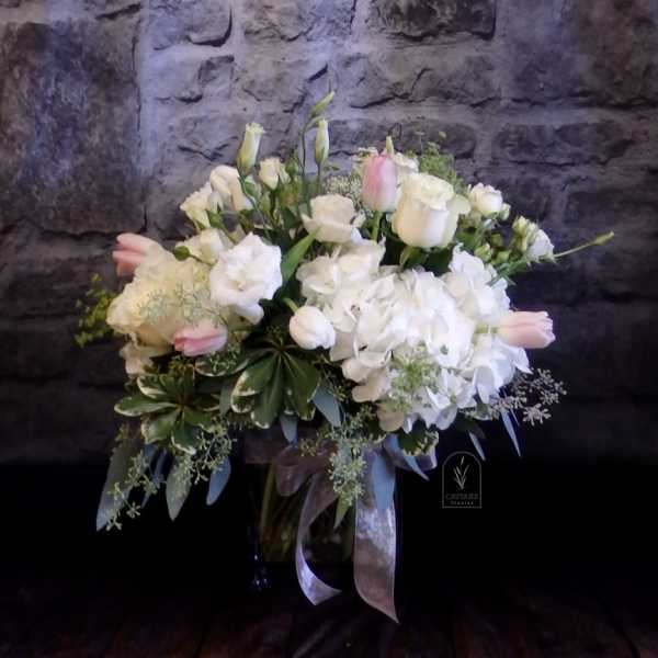 White and blush floral arrangement in a glass vase