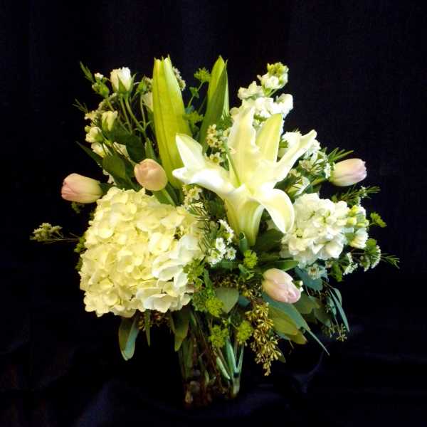 White lilies and pale hydrangeas in a bouquet with pink tulips