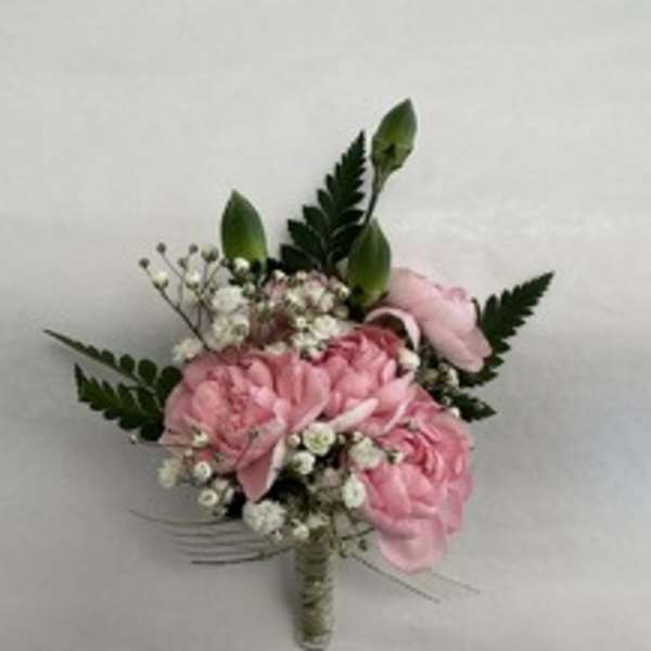 Pink floral bouquet with small white filler flowers and dark green leaves