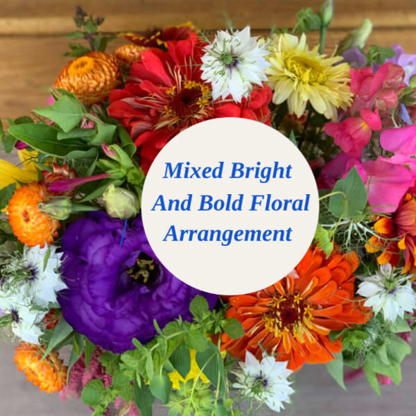 Mixed bright bouquet with colorful flowers and a center label