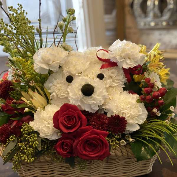 Basket arrangement with a teddy bear made of white carnations and red roses