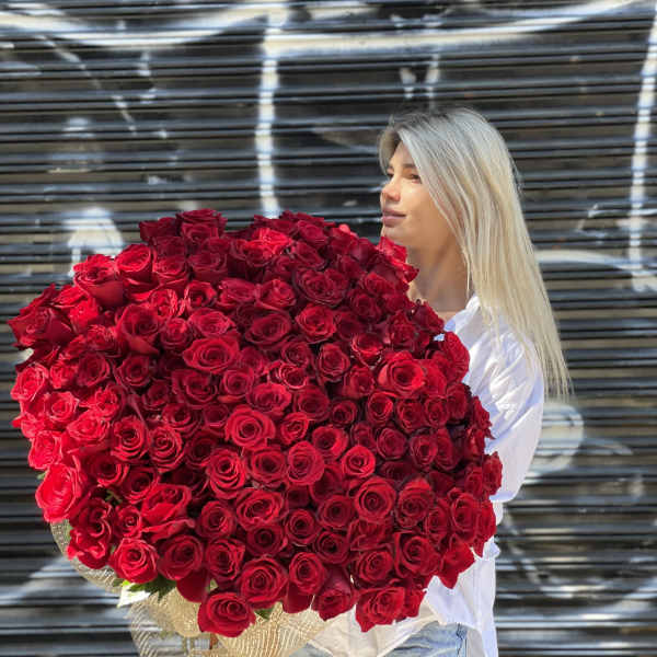 Woman holding a large bouquet of red roses
