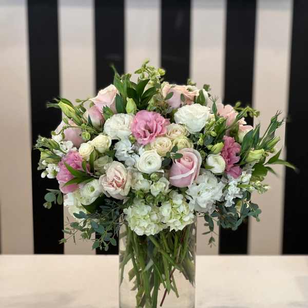 Pink and white roses arranged in a clear glass vase