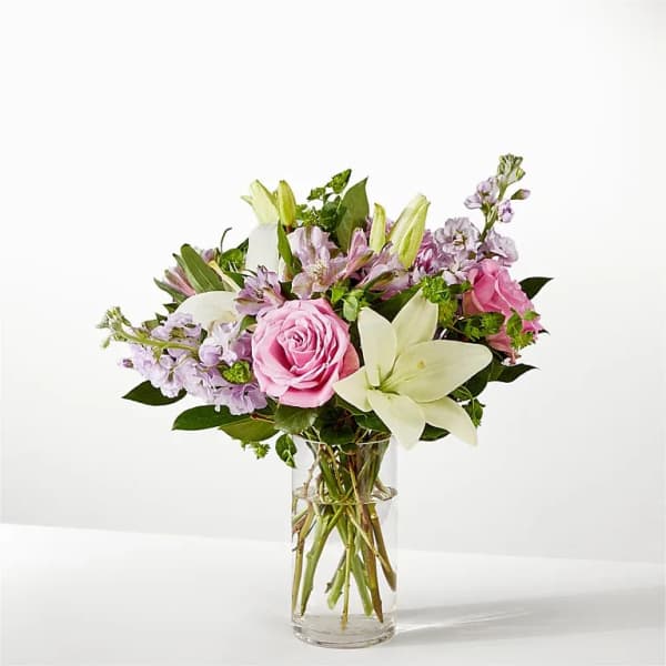 Pink roses and white lilies in a clear glass vase