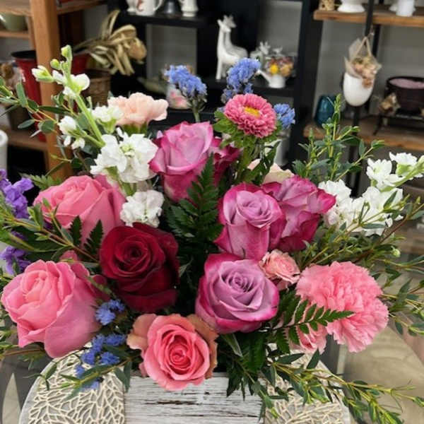 Mixed bouquet of pink and purple roses in a wooden box