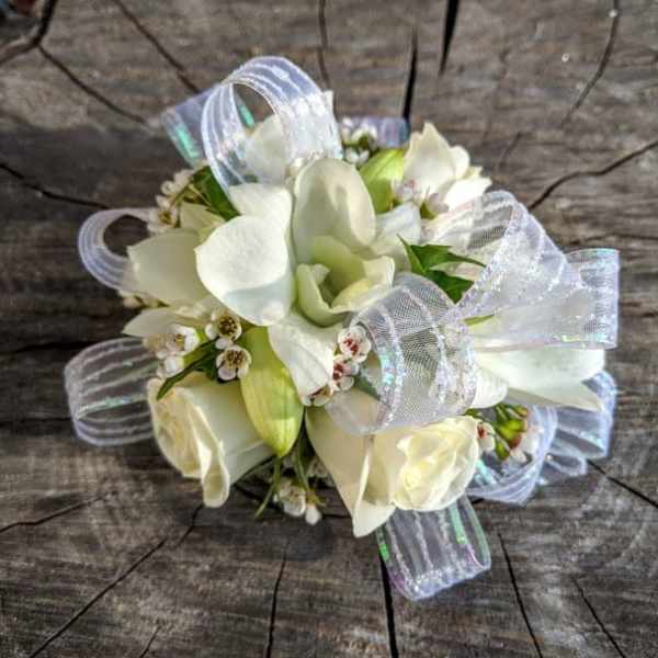 White floral wrist corsage with sheer ribbon loops