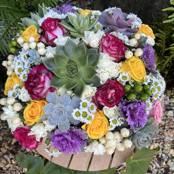 Round bouquet with pink and yellow roses, succulents, and small white daisies