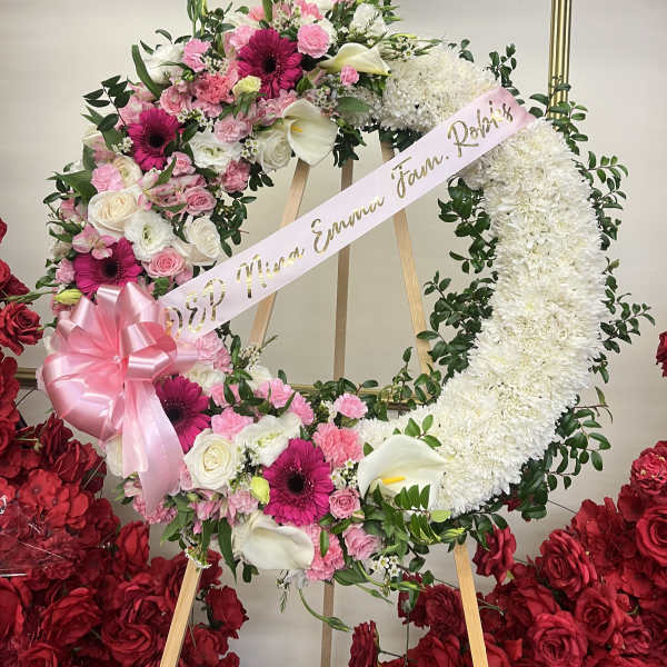 Large floral wreath with pink and white flowers on an easel