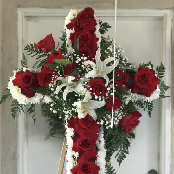 Red rose cross with white flowers on a wooden easel