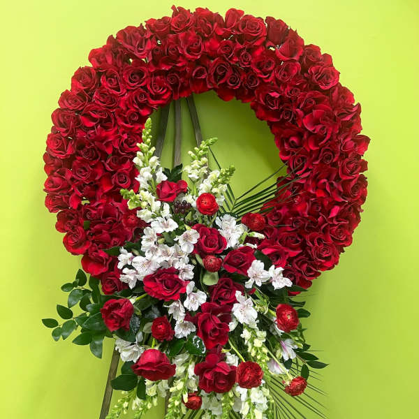 Red rose funeral wreath with white flowers on a stand