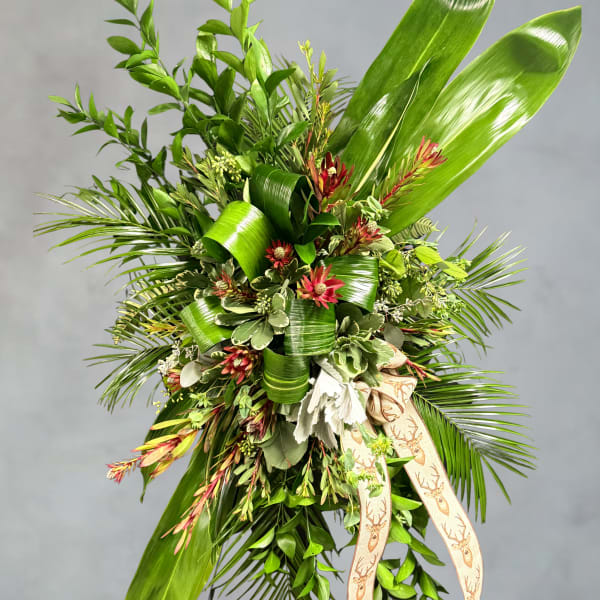 Large green floral spray with red accents and a deer-print ribbon