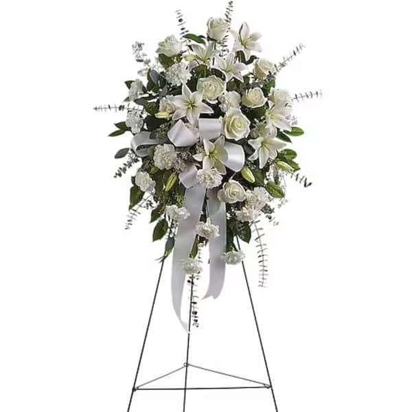 White floral standing spray on an easel with ribbon