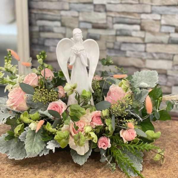 Pink rose arrangement with a white angel figurine centerpiece