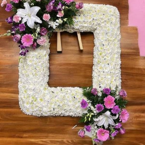 Floral funeral wreath with white and pink flowers in a square frame