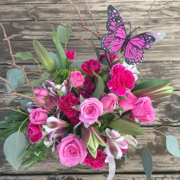 Pink roses and carnations with lilies and a butterfly pick