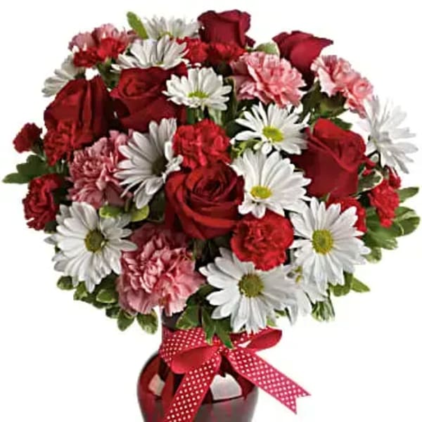 Red roses and white daisies in a red vase with a polka-dot ribbon