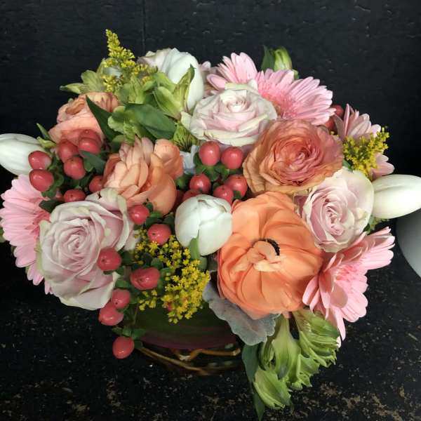 Mixed bouquet with pink roses, peach blooms, and pink daisies in a basket