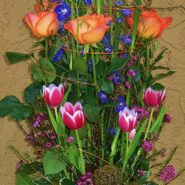 Tall bouquet of blue irises and pink tulips in a glass vase